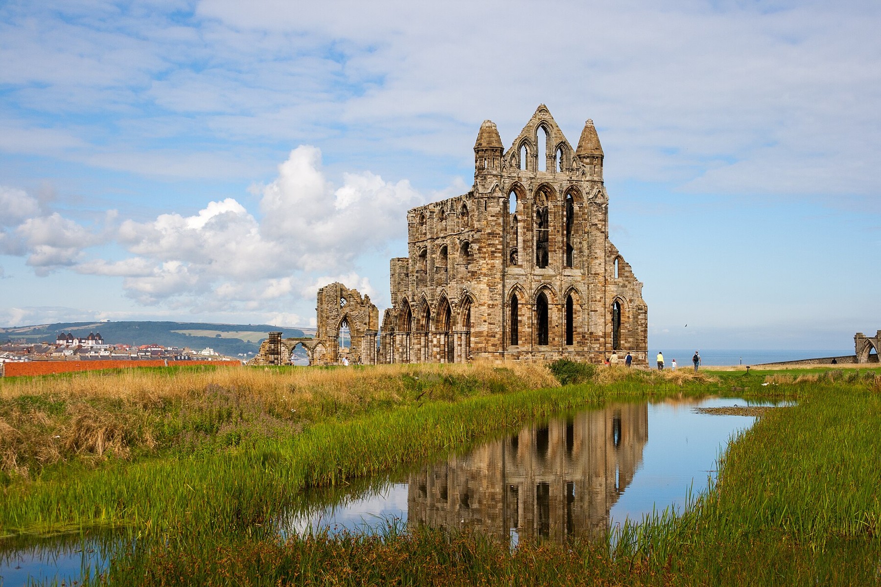 Whitby Abbey ruins reflected in a pond on the headland